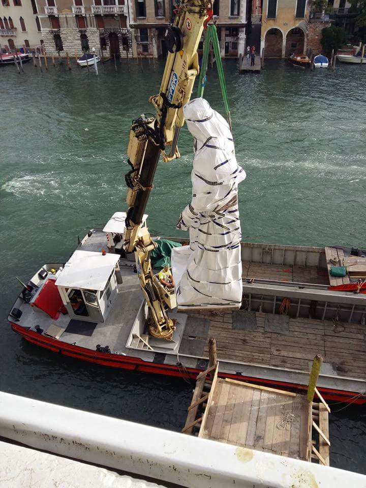 Movimentazione di una statua tramite imbarcazione dotata di gru