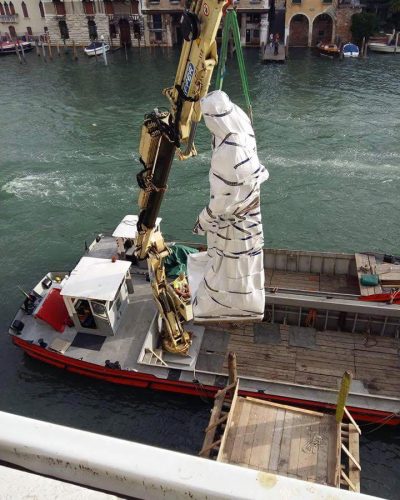 Movimentazione di una statua tramite imbarcazione dotata di gru